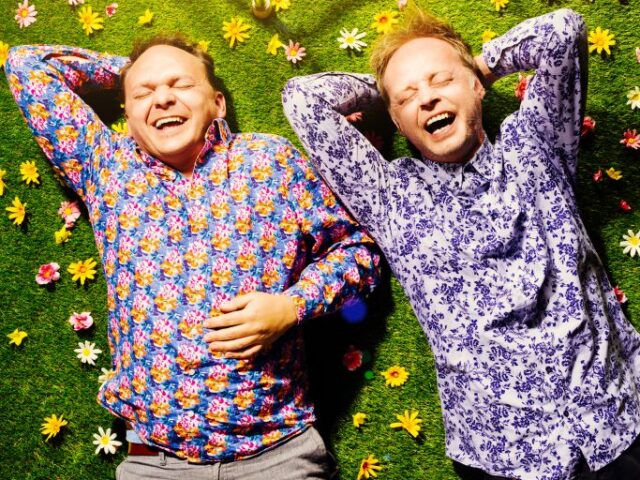 BlöZinger liegen lachend in der Blumenwiese