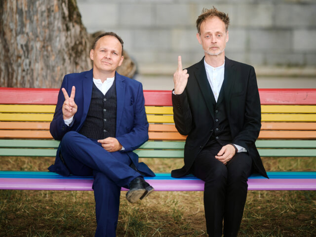 BlöZinger sitzen auf einer regenbogen-bunten Parkbank
