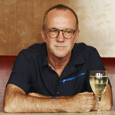 Daniel Glattauer sitzt bei Tisch, vor ihm steht ein mit Weißwein gefülltes Weinglas.